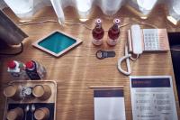 a table with a phone and bottles of beer at Maison Nô - Hôtel et Rooftop in Lyon