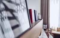 a living room with a television and a book shelf at Maison Nô - Hôtel et Rooftop in Lyon
