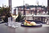 a plate of food and a glass of wine on a table at Maison Nô - Hôtel et Rooftop in Lyon