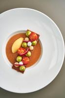 a white plate with a piece of food with vegetables on it at Maison Nô - Hôtel et Rooftop in Lyon