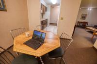 a laptop sitting on a wooden table with chairs at Wedgewood Resort in Fairbanks