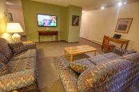 a living room with couches and a flat screen tv at Wedgewood Resort in Fairbanks