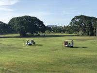a group of people standing in a field with golf carts at Argus Apartments Darwin in Darwin
