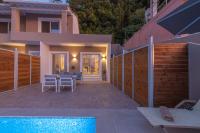 a house with a swimming pool and a fence at Valtes Luxurious Apartments in Mpoukaris
