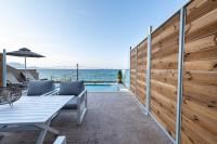 a patio with a table and a fence and the ocean at Valtes Luxurious Apartments in Mpoukaris