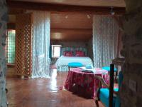 a bedroom with a bed and a table with chairs at Riverside Home Cottage in Trèbes