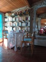 a dining room with a table and chairs and books at Riverside Home Cottage in Trèbes