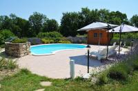 una casa y una piscina con sombrilla y sillas en Gîte Bois et Senteurs, en Lafrançaise