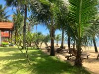 a park with benches and palm trees on the beach at Peppercorn Beach Resort in Phú Quốc