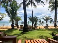 a group of benches on a beach with palm trees at Peppercorn Beach Resort in Phú Quốc