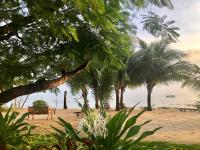 a park with a bench and palm trees on the beach at Peppercorn Beach Resort in Phú Quốc