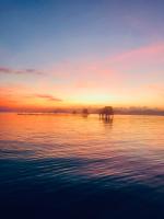 a sunset over a body of water with an island at Peppercorn Beach Resort in Phú Quốc