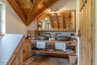 a bathroom with two sinks and a wooden ceiling at Almchalet Linharterhof in Haus im Ennstal