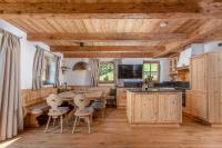 a kitchen with wooden cabinets and a table and chairs at Almchalet Linharterhof in Haus im Ennstal