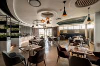 Un restaurante con mesas, sillas y ventanas. en Seven Villa Hotel & Spa, en Johannesburgo