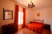 a bedroom with a red bed and a mirror at Casa Rural El Limonero in Los Naveros