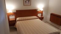 A bed or beds in a room at Hostal Forum