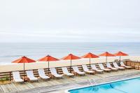 Una piscina con sillas y sombrillas y la playa. en Marram, en Montauk
