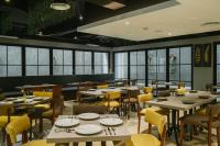 een eetkamer met tafels en stoelen en ramen bij Barito Mansion in Jakarta