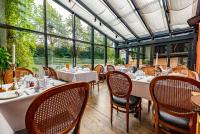 Un comedor con mesas y sillas y ventanas. en GamlaVærket Gjæstgiveri og Tracteringssted, en Sandnes