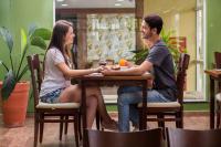 a man and woman sitting at a table in a restaurant at Spazio Marine Hotel - Guaratuba in Guaratuba