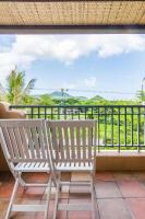 two chairs sitting on a balcony with a view of the ocean at Fairyland &amp; Farm Guest House in Kenting