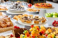 een tafel vol verschillende soorten gebak en gebak bij Hotel Alexander in Bibione