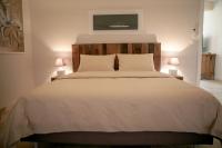 a bedroom with a large white bed with two lamps at Les Pins de l&#39;Escalet in Ramatuelle