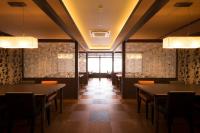 Un comedor con mesas y sillas y una ventana. en Umiusagi, en Higashiizu