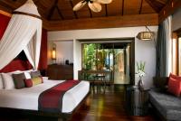 a bedroom with a bed and a couch at Anantara Rasananda Koh Phangan Villas in Thong Nai Pan Noi