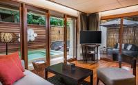 a living room with a couch and a television at Anantara Rasananda Koh Phangan Villas in Thong Nai Pan Noi