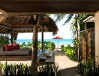 a resort with a bed and an umbrella and the ocean at Anantara Rasananda Koh Phangan Villas in Thong Nai Pan Noi