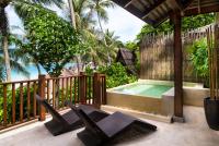 a deck with black chairs and a swimming pool at Anantara Rasananda Koh Phangan Villas in Thong Nai Pan Noi