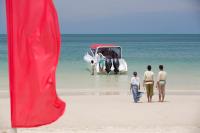 a group of people walking on the beach with a boat at Anantara Rasananda Koh Phangan Villas in Thong Nai Pan Noi