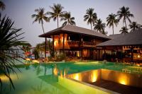 a swimming pool in front of a building with palm trees at Anantara Rasananda Koh Phangan Villas in Thong Nai Pan Noi
