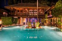 a swimming pool in front of a building at night at Anantara Rasananda Koh Phangan Villas in Thong Nai Pan Noi