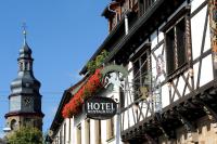 a hotel sign on the side of a building with a tower at Weinkastell Zum Weissen Ross in Kallstadt