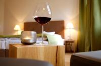 a glass of wine sitting on a table in a hotel room at Weinkastell Zum Weissen Ross in Kallstadt