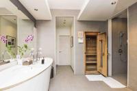 a bathroom with a tub and a sink and a shower at Chatrium Hotel Riverside Bangkok in Bangkok