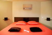 a bed with orange sheets and pillows on it at Chez Tatiana in Lyon