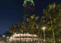 a tall building with palm trees in front of it at Chatrium Hotel Riverside Bangkok in Bangkok