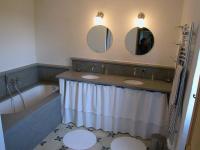 a bathroom with two sinks and a tub and two mirrors at le mas du cypres, 12 pers et piscine in Aigaliers
