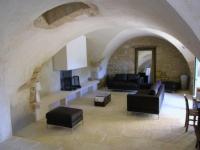 a living room filled with furniture and a stone wall at le mas du cypres, 12 pers et piscine in Aigaliers