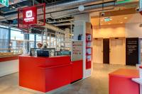 a fast food restaurant with a red counter at MEININGER Hotel Heidelberg Hauptbahnhof in Heidelberg