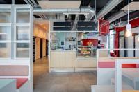 a fast food restaurant with a counter in the middle at MEININGER Hotel Heidelberg Hauptbahnhof in Heidelberg