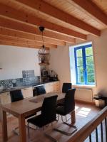 a kitchen with a wooden table and chairs and a window at Gîte les Pieds dans l&#39;eau bord de Sèvre, 10 min du Puy du Fo in Treize-Vents