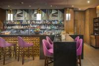 Un bar con sillas moradas en un restaurante. en Catalonia Santo Domingo, en Santo Domingo