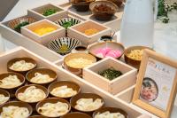 Una mesa con cuencos de madera con comida encima. en Vessel Hotel Campana Nagoya, en Nagoya