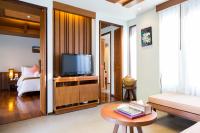 a living room with a television and a bed at Maehaad Bay Resort - SHA Plus in Mae Haad