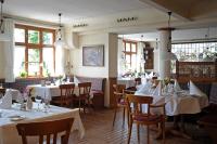 a restaurant with white tables and chairs and windows at MICHELS Wellness- & Wohlfühlhotel in Schalkenmehren